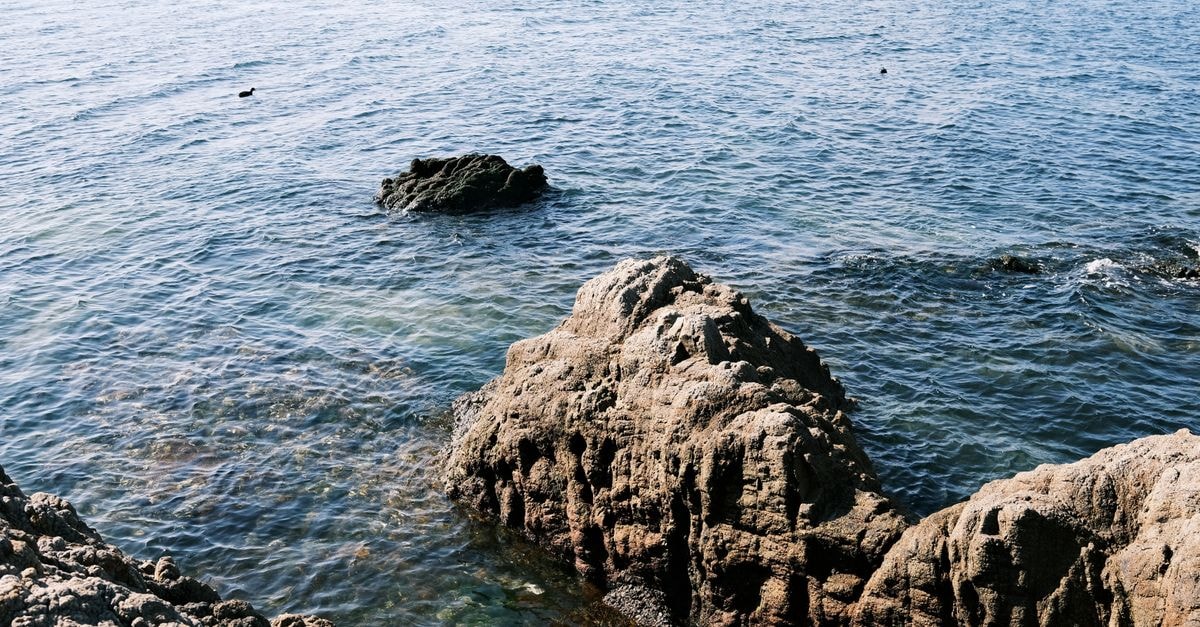 Peaceful view of rocky coastline and blue sea at Gamagōri, Japan.