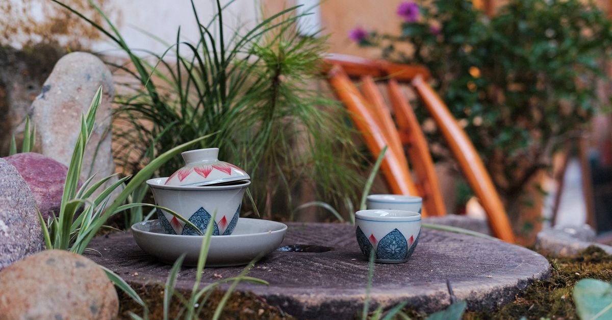 Ji Hotel Hezhou Lingfeng Square: Huazhu Mid-Range Brand on Lingfeng North Road Beautiful traditional tea set placed on wooden surface amidst natural greenery in an outdoor garden, Hezhou, China.