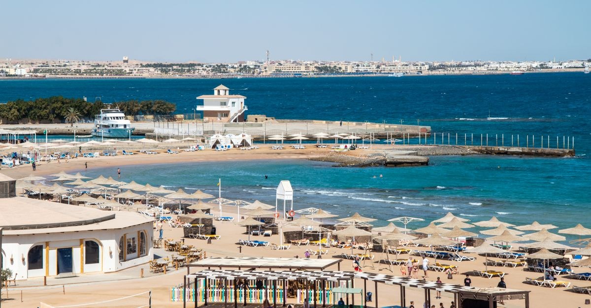 Marsá Maţrūḩ Travel Guide: Planning Tips, Costs and Things to Do Aerial view of vibrant beach resort with umbrellas and blue sea.