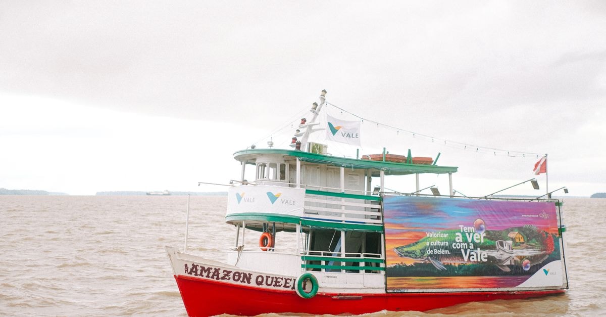 Abaetetuba Travel Guide: Amazon Rhythm by Water and Road A colorful boat named Amazon Queen cruising on the Amazon River under a cloudy sky.
