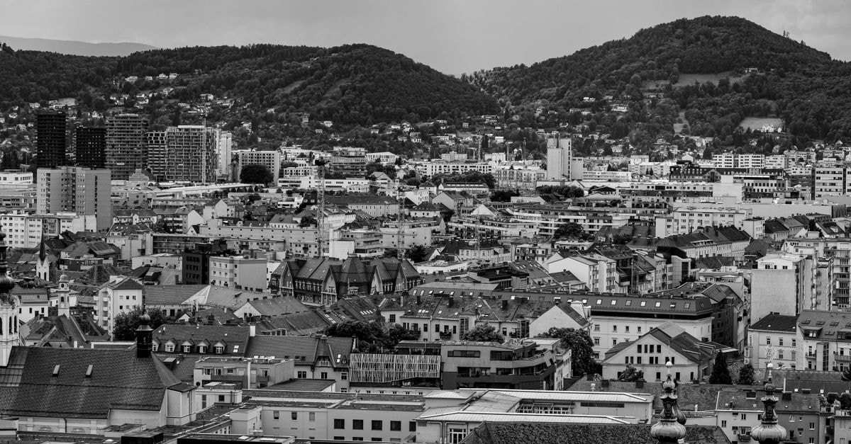 Park Inn Linz: Central Hessenplatz Setting in the Innere Stadt Aerial view of a cityscape with hills in the background in black and white.
