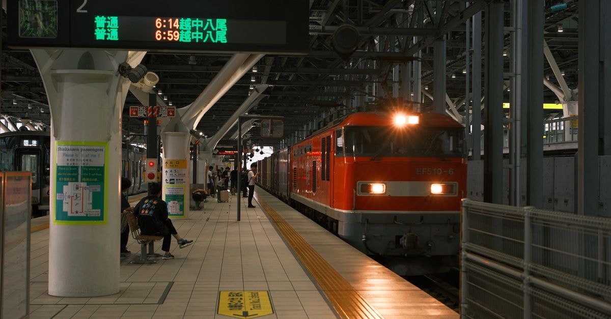 Wallabies arrive in Osaka for Saturday Test against Eddie Jones' Japan amid record heatwave A vibrant red train arrives at a bustling Japanese station, capturing the essence of urban transit.