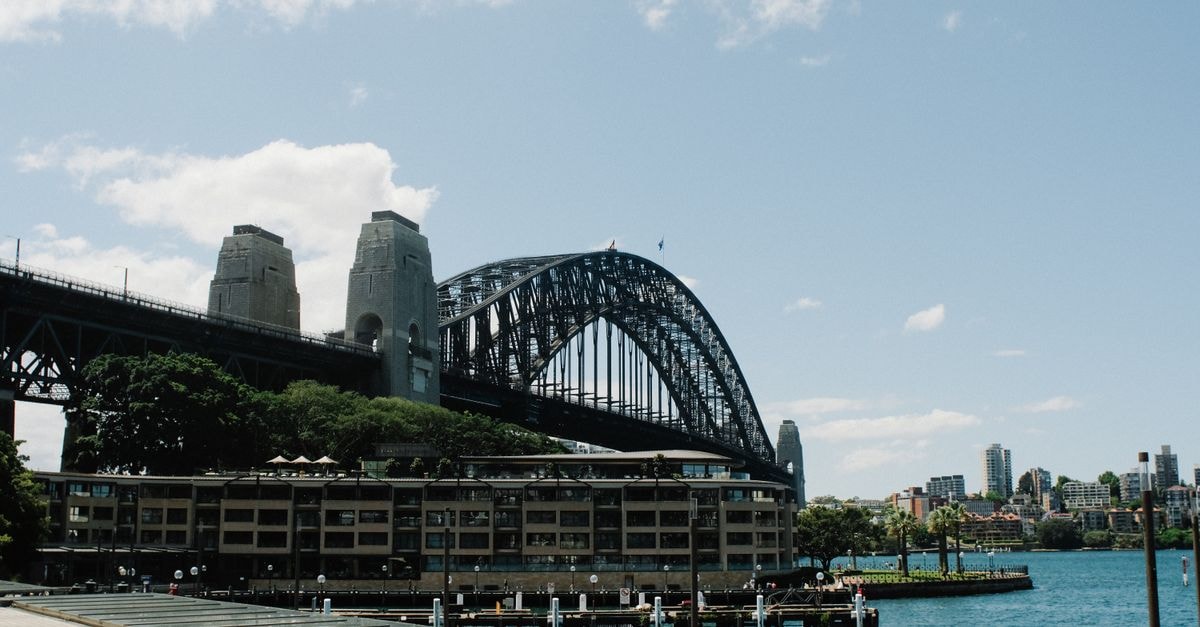 Iconic Sydney Harbour Bridge against a blue sky with the city skyline.