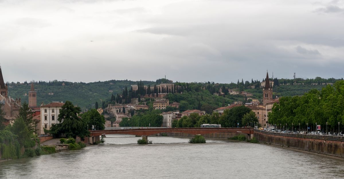 Hotel Mastino Verona: A 3-Star City Hotel on Corso Porta Nuova Near the Arena Scenic view of Adige River and Verona cityscape on a cloudy day, showcasing local landmarks and lush greenery.