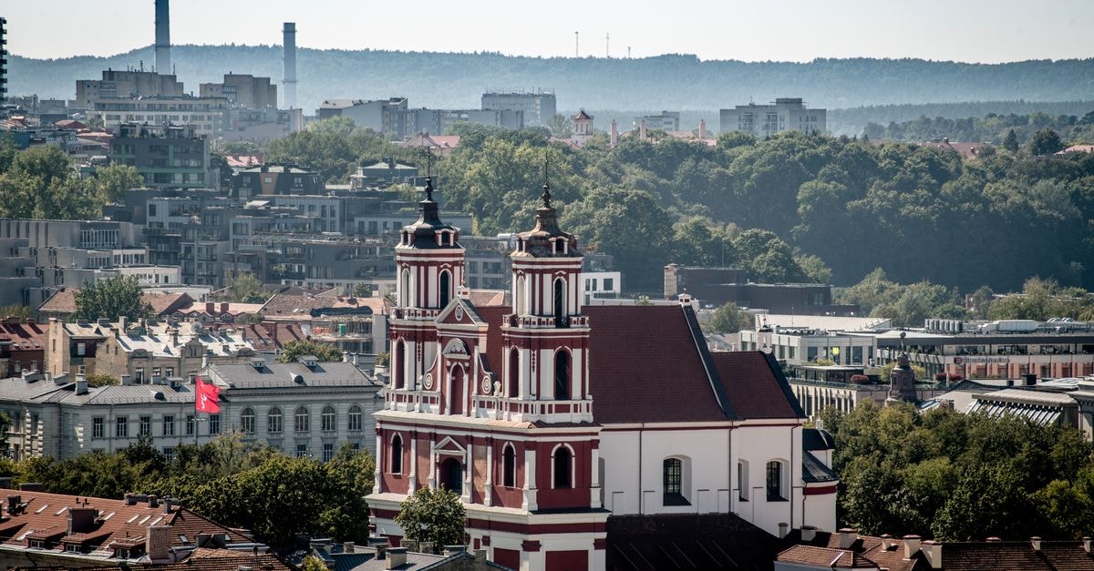 Neringa in Vilnius: A Gediminas Avenue Stay with Indoor Pool Aerial view of St. Catherine's Church amidst Vilnius cityscape on a sunny day.