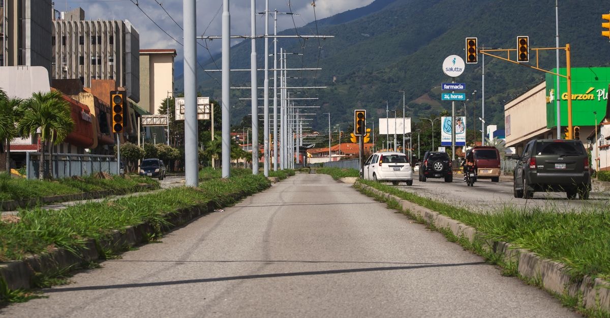 Valencia, Venezuela Travel Guide: Culture, Food, and the City's Pulse A bustling urban street scene in Mérida, Venezuela, featuring traffic and distant mountains.