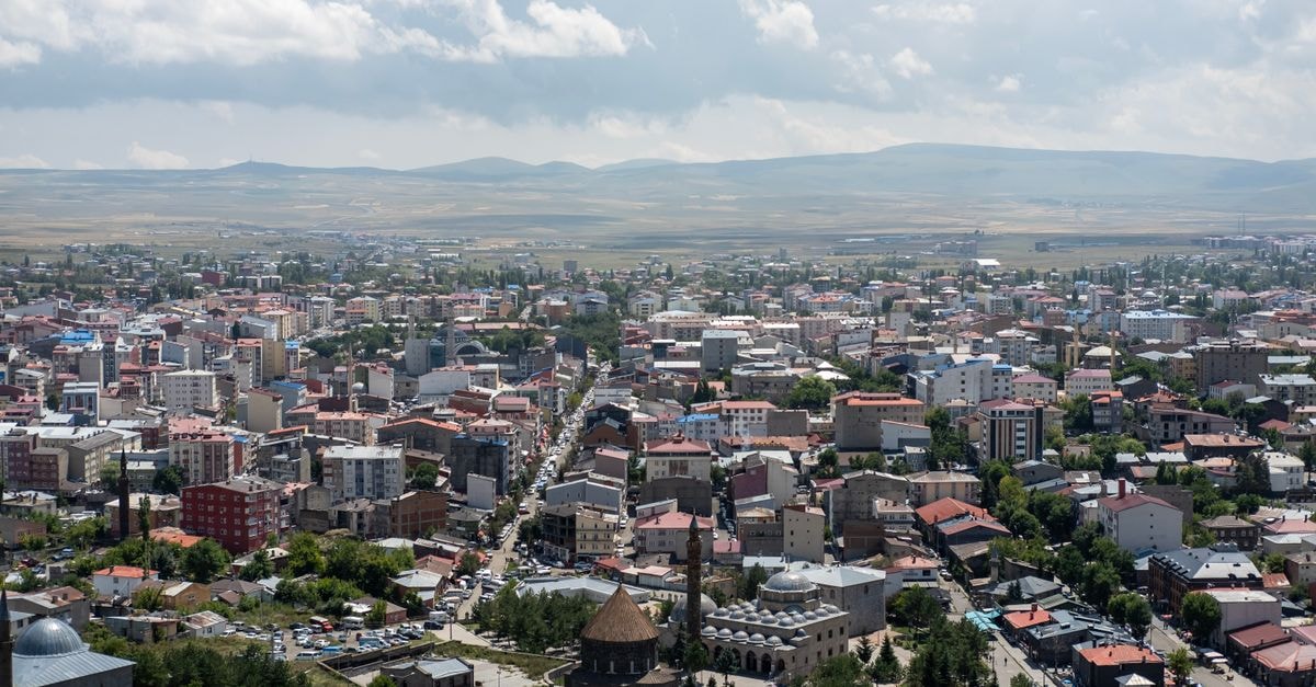 A scenic aerial view of Kars, Türkiye, showcasing its urban landscape, buildings, and distant hills.