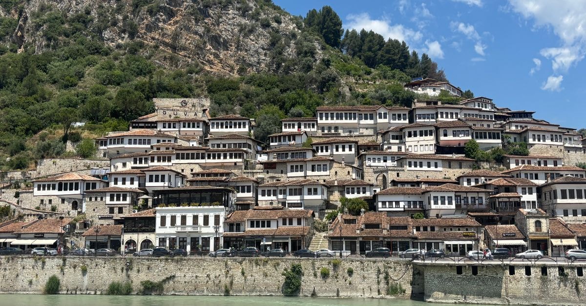 Scenic view of Berat, Albania showcasing traditional Ottoman houses against a hillside.