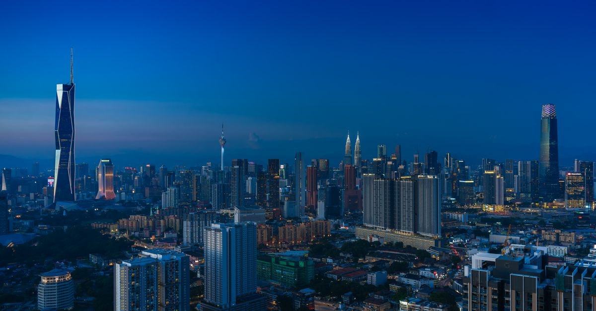 Le Méridien Kuala Lumpur: Steps from Malaysia's KL Sentral Hub Discover the vibrant Kuala Lumpur skyline featuring iconic landmarks in the evening glow.