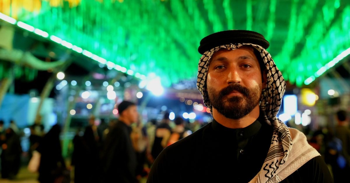 Karbala Travel Guide: Getting There and Getting Around Portrait of a man during Arbaeen pilgrimage in Karbala, Iraq, with vibrant lighting.