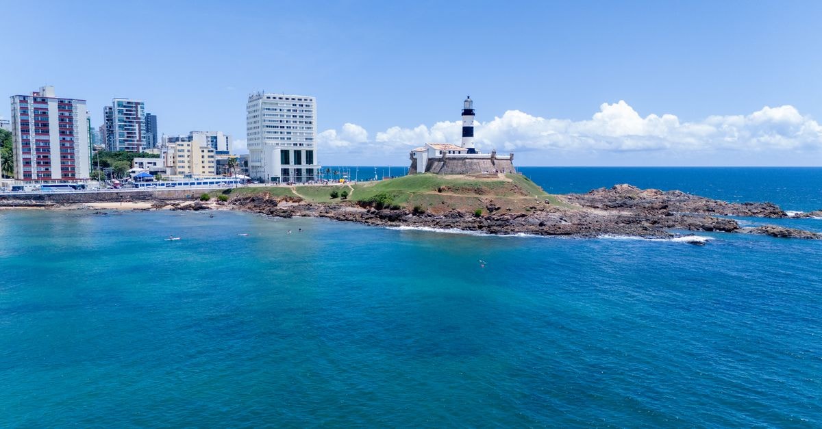 Aerial view of Barra Lighthouse and coastal skyline in sunny Salvador, Brazil.