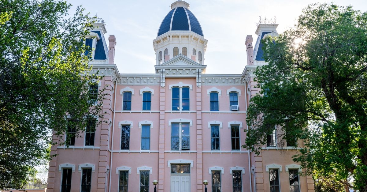 Carson City Travel Guide: Getting Around and Eating Well Front view of the iconic Presidio County Courthouse in Marfa, Texas, framed by trees under a clear sky.