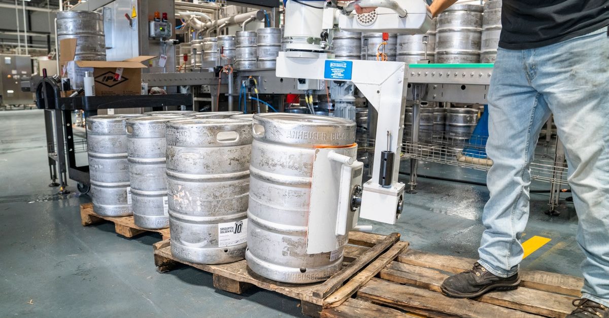 STERIS plc: Premium-Priced Medical-Sterilization Compounder A worker operates machinery to stack steel kegs in a brewery warehouse.