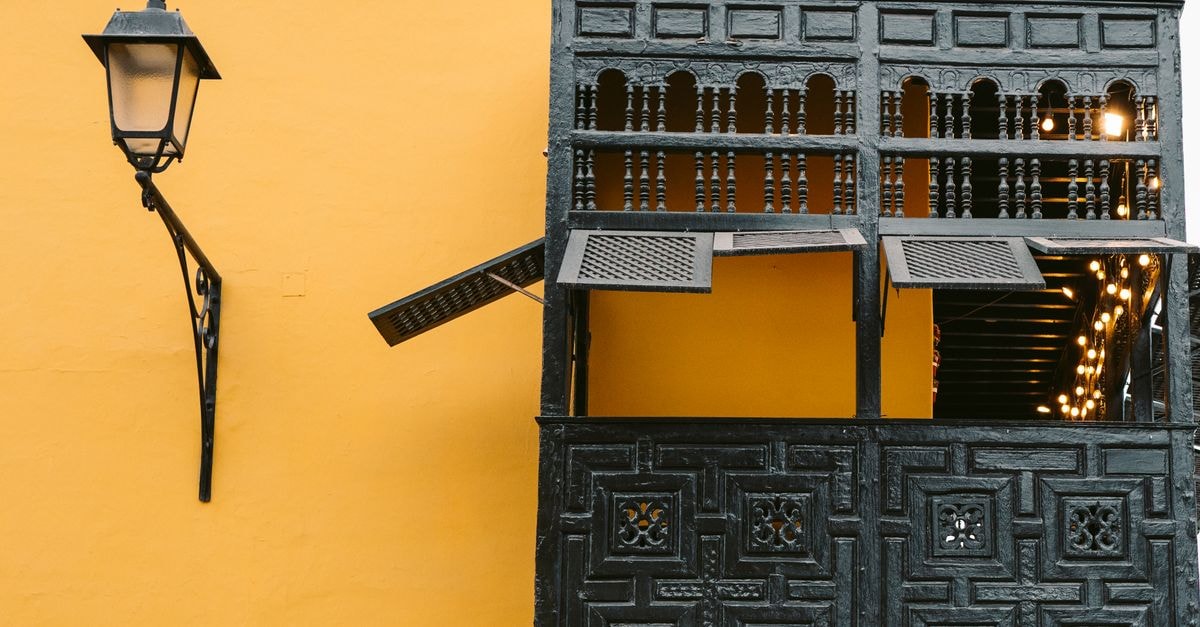Historic wooden balcony on a vibrant yellow wall in Trujillo, Peru.