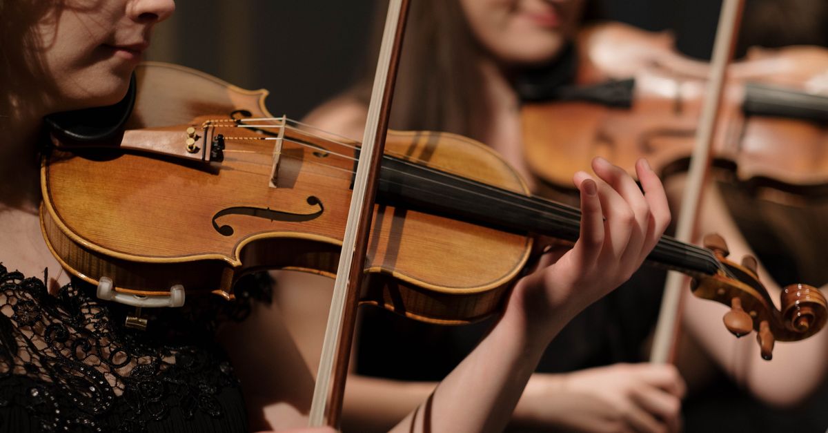 Global Classical Music Festivals Showcase Premieres, Tributes and Inaugural Events Musicians performing classical music with violins, showcasing skill and concentration.