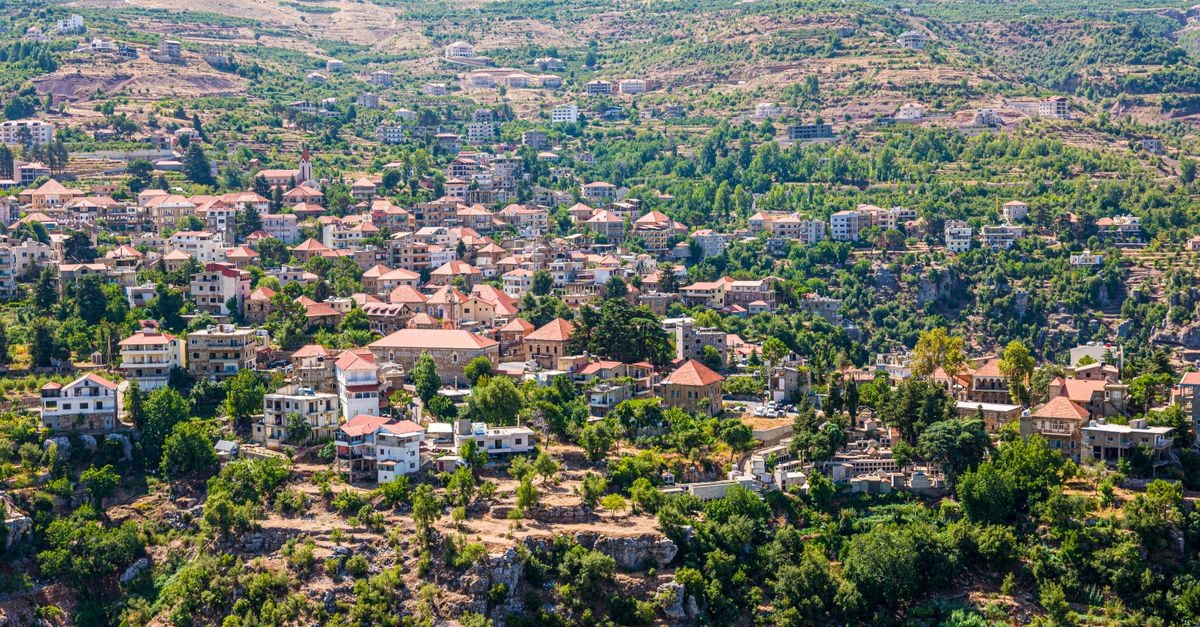 Tiaret Travel Guide: Planning Tips, Costs and Things to Do Breathtaking aerial view of a quaint village nestled in lush mountain terrain, showcasing stunning architecture.