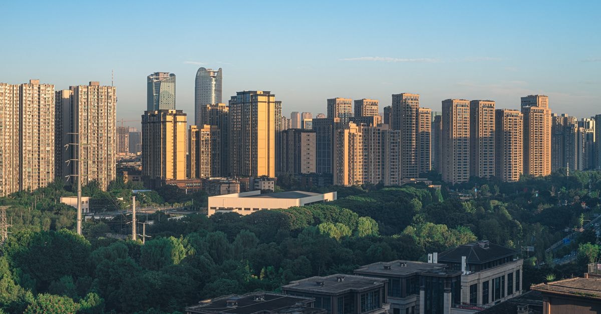 Huacheng Hotel, Baoshan: A Convenient Stop Near the Airport Panoramic view of a modern skyline with prominent skyscrapers and lush greenery.