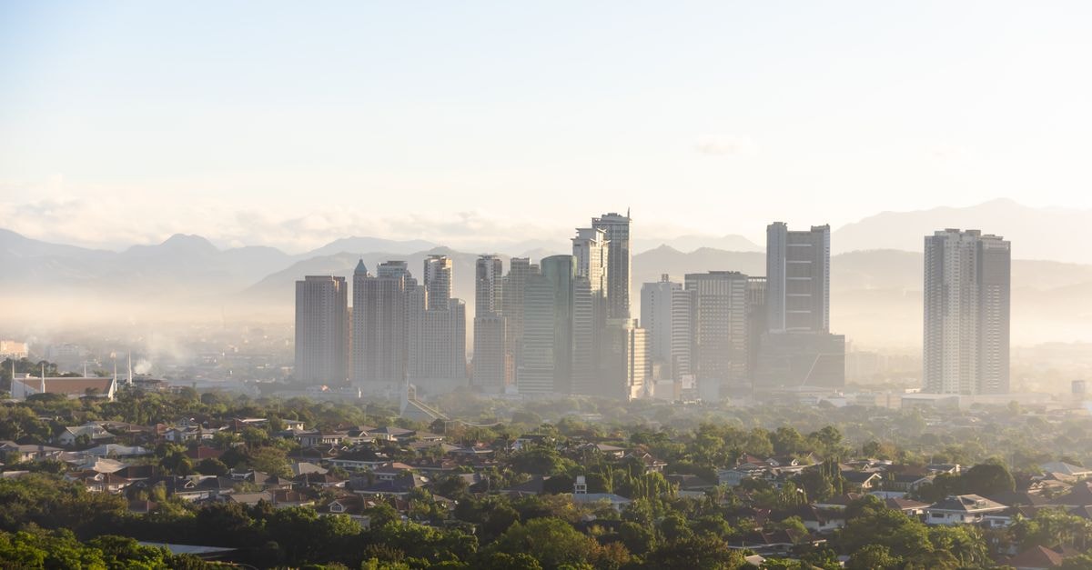 New Dawn Hotel Plus in Cagayan de Oro: A Central City Stay Panoramic view of Quezon City skyline with buildings emerging from the morning fog.