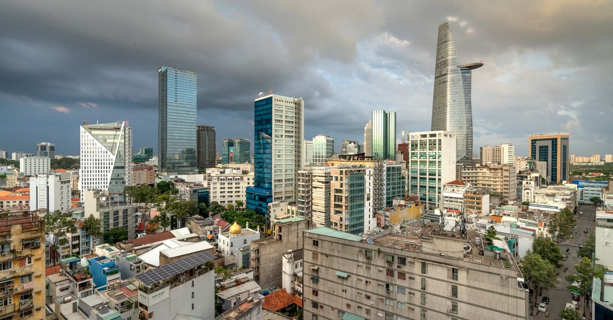 Khách Sạn Minh Tâm in Ho Chi Minh City: A District 3 Base Near the War Remnants Museum Ho Chi Minh City's skyline with modern skyscrapers against an overcast sky, captured in a stunning aerial view.