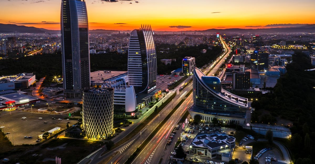 Sofia Balkan Palace in Sofia: A 1956 Icon Above a Roman Fortress A breathtaking aerial view of Sofia, Bulgaria at sunset highlighting modern architecture and city lights.