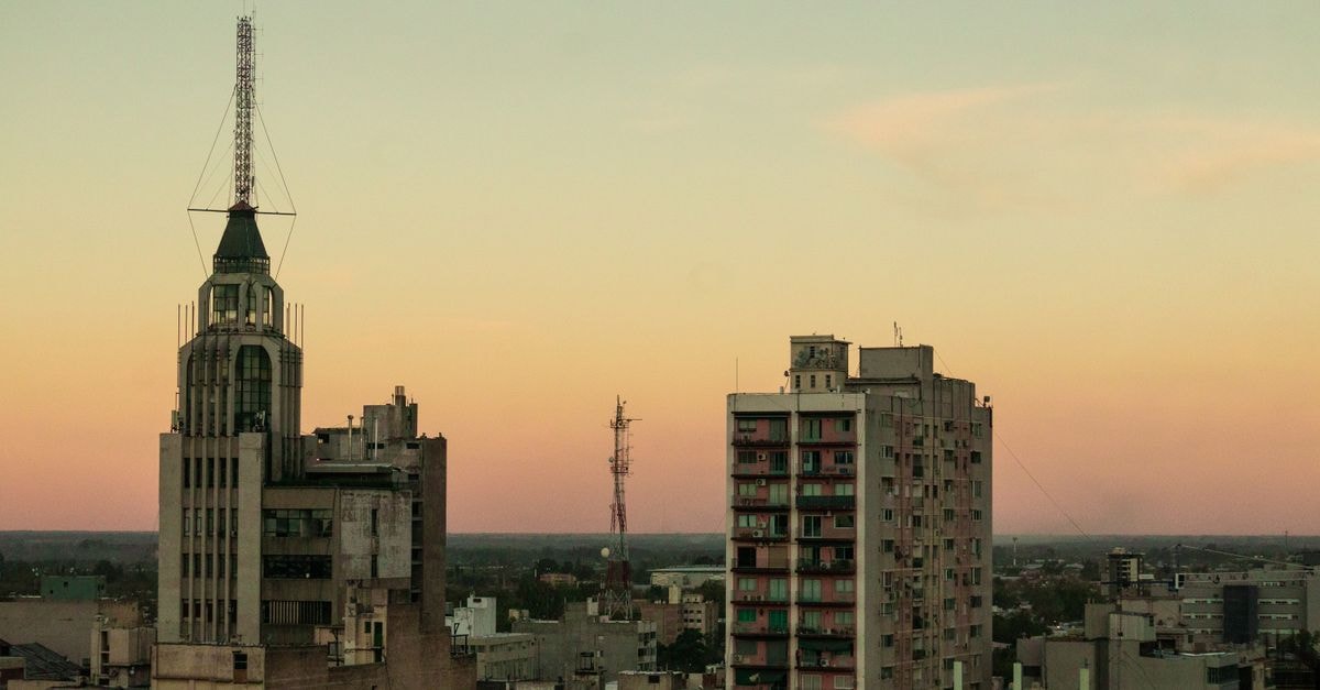 View of Mendoza city skyline at sunset, featuring prominent buildings and towers.