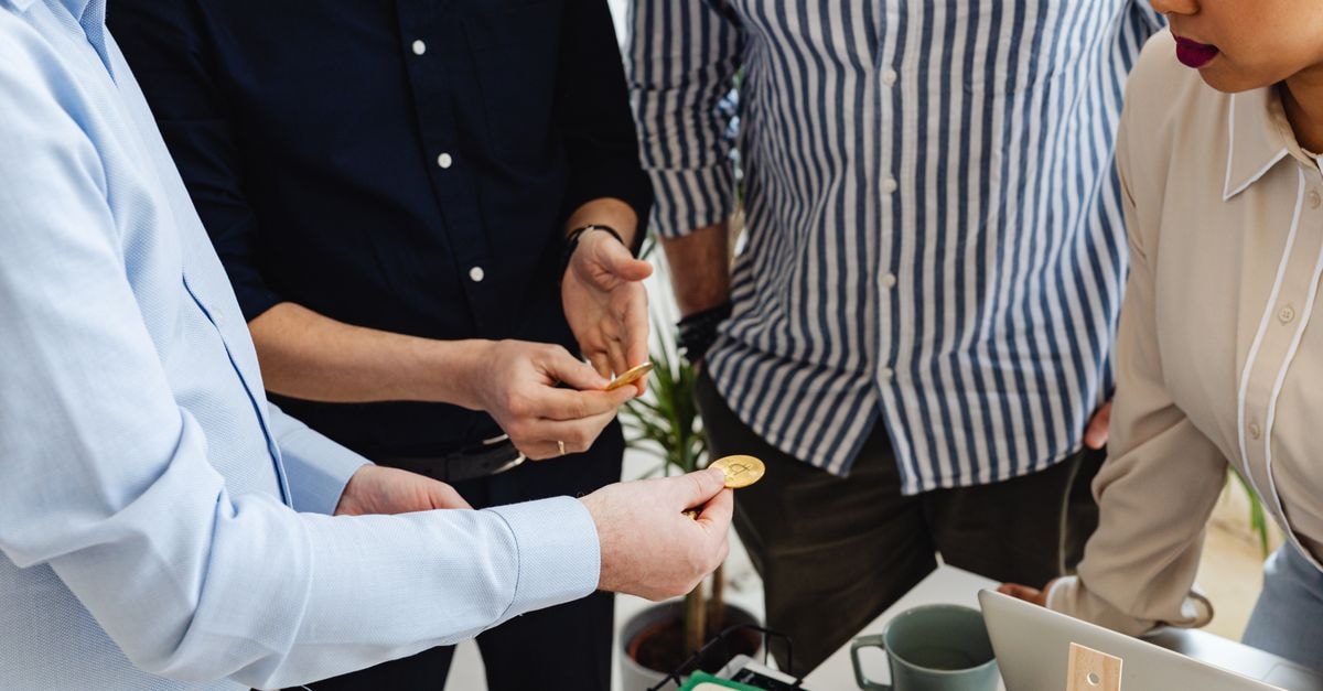 Business colleagues working with Bitcoin during a meeting, exchanging ideas in office setting.