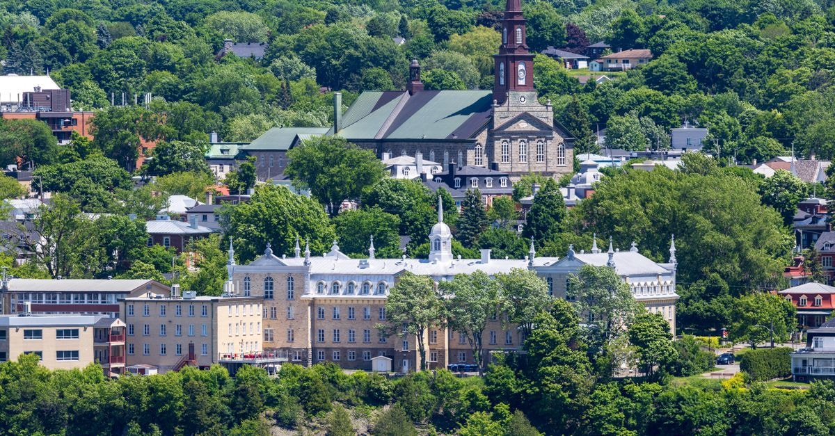 Stunning aerial view of Quebec City's historic buildings surrounded by lush greenery in summer.
