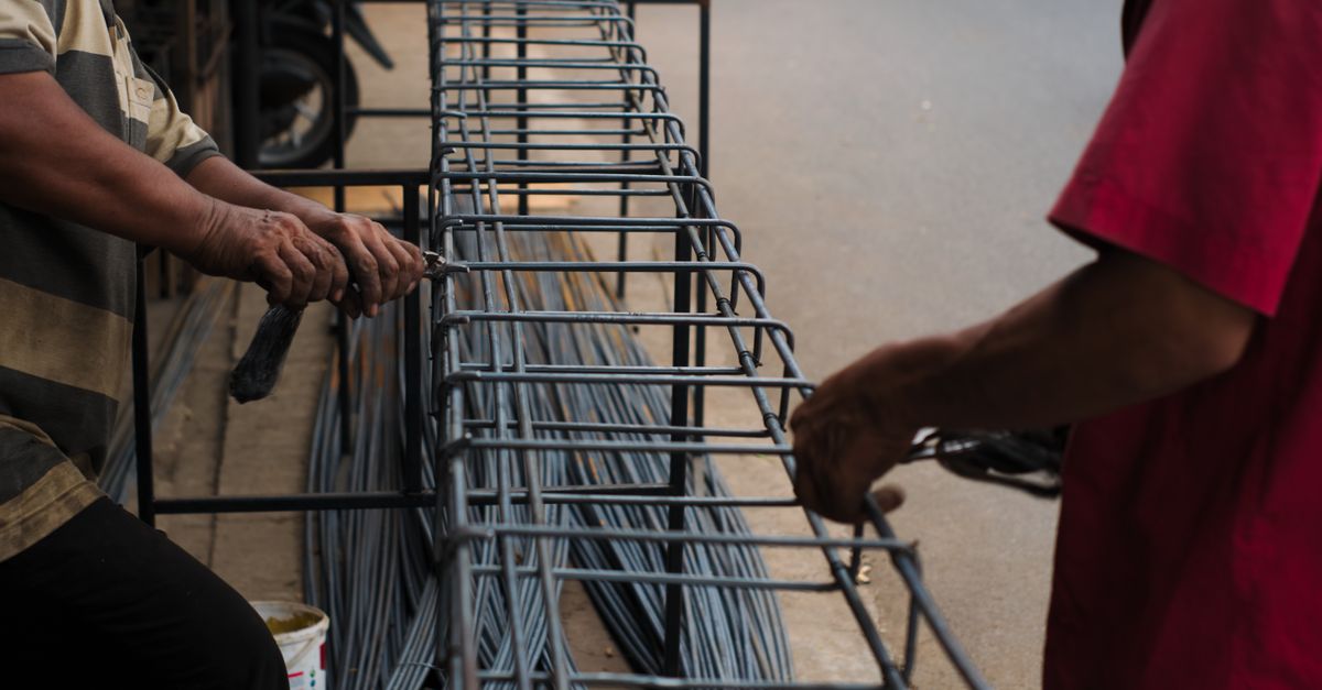 India steel outlook improves with rebar recovery as Tata Steel UK warns of Asian import surge and US presses Mexico on tariffs Workers manually assembling steel rebars for a construction project in an Indonesian setting.