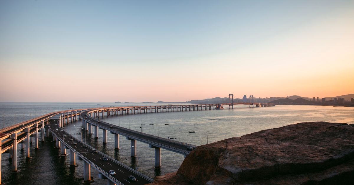 Captivating sunset view of Xinghaiwan Bridge spanning the sea in Dalian, Liaoning province.