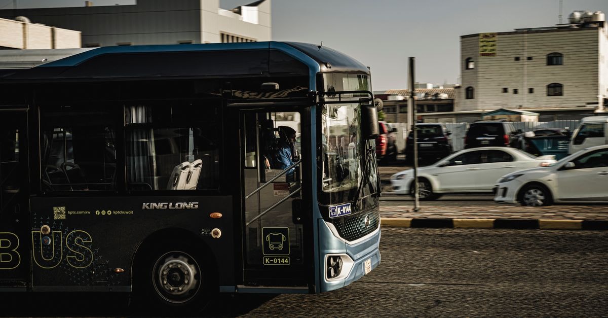Seeb Travel Guide: Getting Around, Local Etiquette, and What to Know Public transport bus driving in Kuwait City, showcasing urban transit and vehicles.