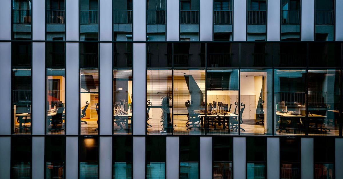Adobe patches eight critical Campaign Classic flaws; build 9403 fixes the reported exposure Illuminated office inside a modern glass building exterior, showcasing architecture and workspace design.
