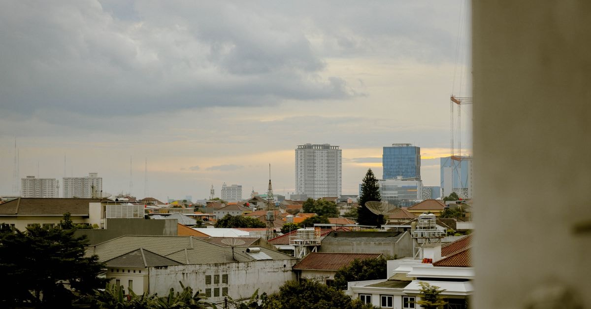 A serene view of West Jakarta's skyline as the sun sets, highlighting urban architecture.