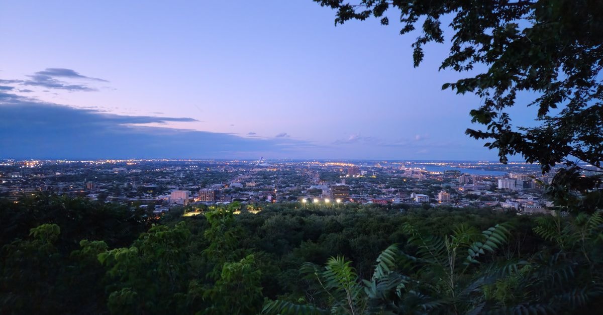 Amérian Hotel Casino Gala in Resistencia: Casino, Pool Terrace & Downtown Address A stunning cityscape view at twilight featuring lush greenery and distant city lights.