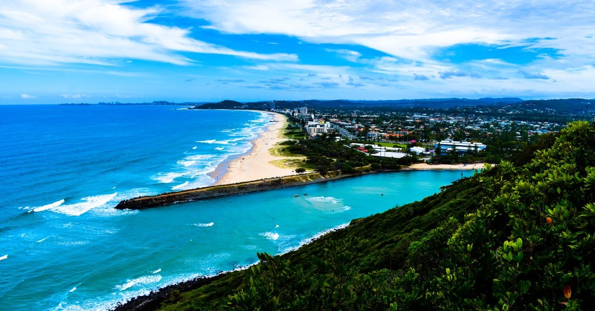 Novotel Sunshine Coast Resort: Lagoon-Side Stay Near Twin Waters Beach A breathtaking aerial view of a tropical beach with lush greenery and vibrant ocean waves.