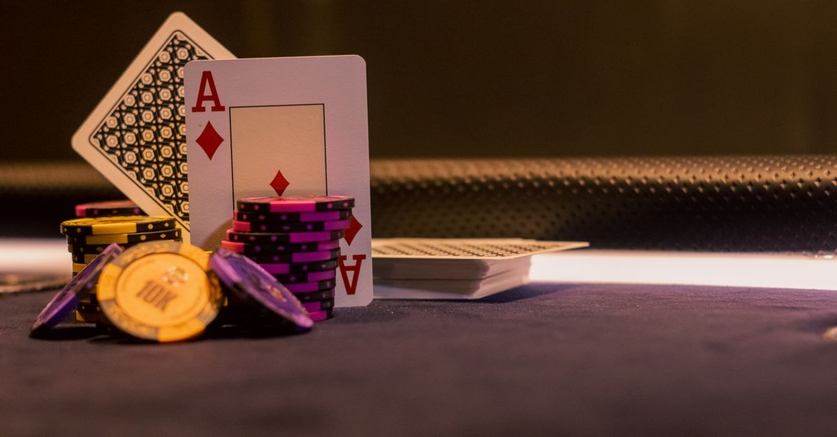賭場遊戲桌上的撲克牌籌碼與紙牌特寫，突顯方塊 Ace。
