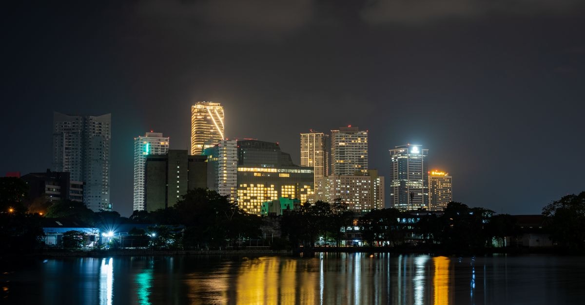 Hotel Savoy, Beira: A Storied Landmark on Rua Pedro Álvares Cabral Illuminated skyline reflecting on water at night, showcasing modern architecture.
