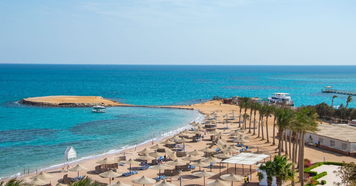 Sohag Travel Guide: Planning Tips, Costs and Things to Do Idyllic beach scene with rows of umbrellas and azure ocean, perfect for travel and relaxation themes.