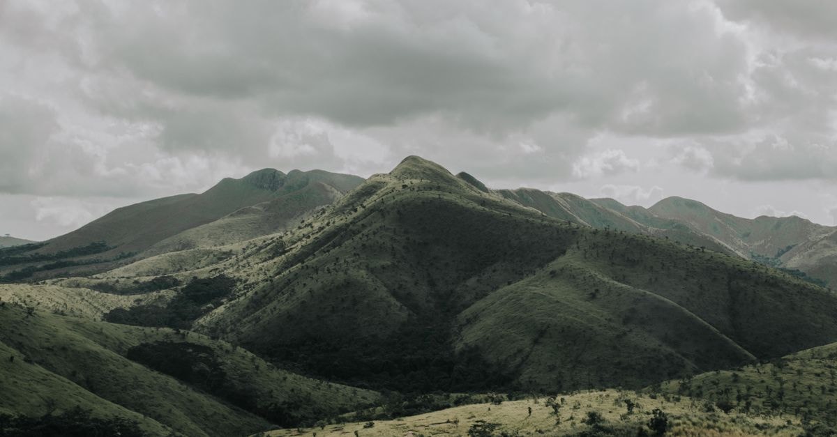Breathtaking view of green hills with clouds overhead in Kwanza-Norte, Angola.