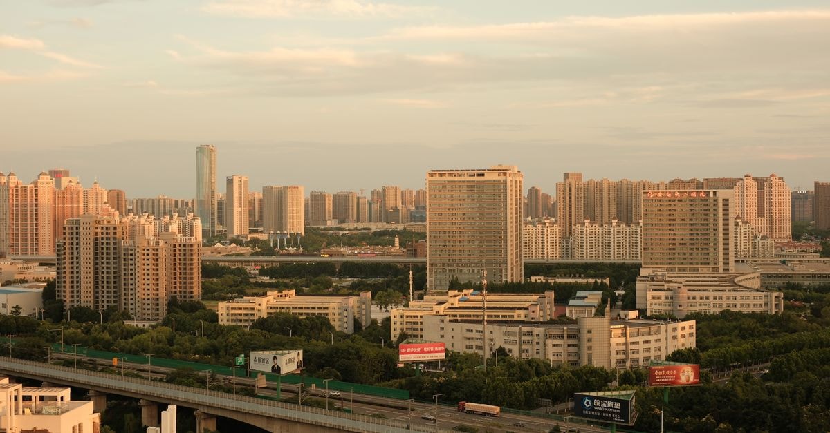 Shangri-La Changchun in the heart of Jilin's capital: where business towers meet puppet-history boulevards A quiet urban skyline with tall buildings and expansive highway at sunset.