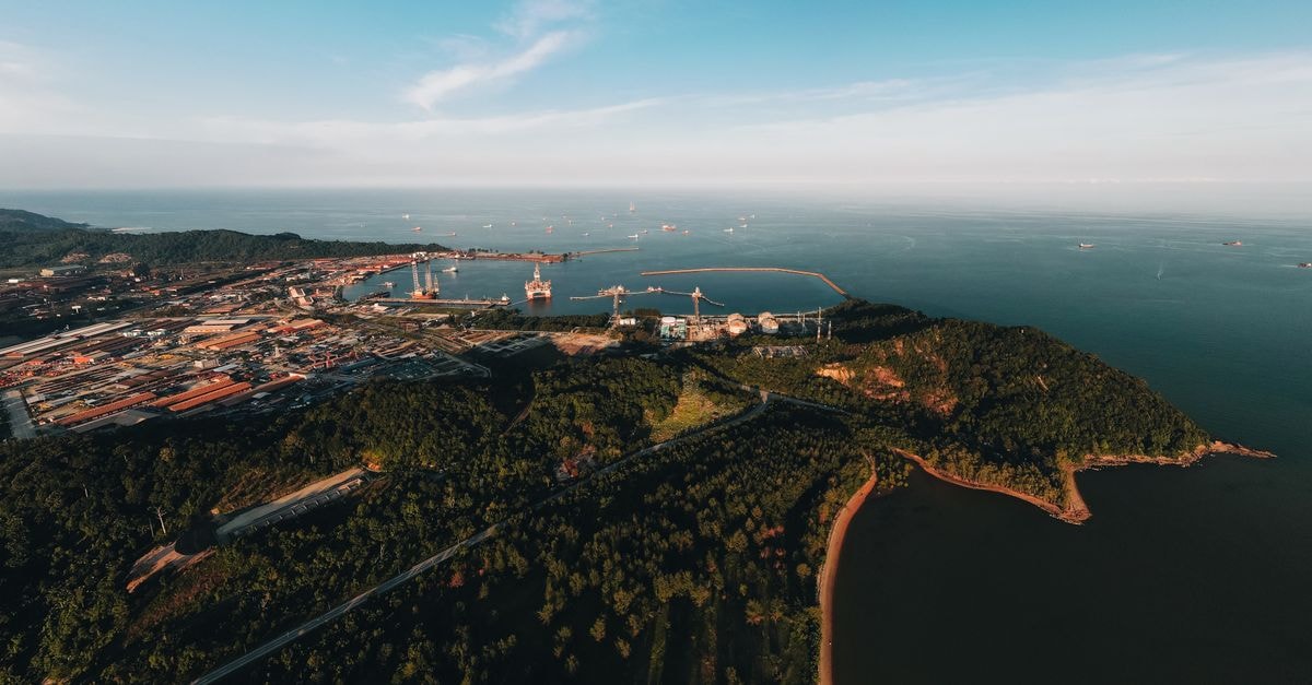 Sorong travel guide: a coastal gateway worth slowing down for Stunning aerial view of a coastal landscape featuring a busy port and lush greenery.