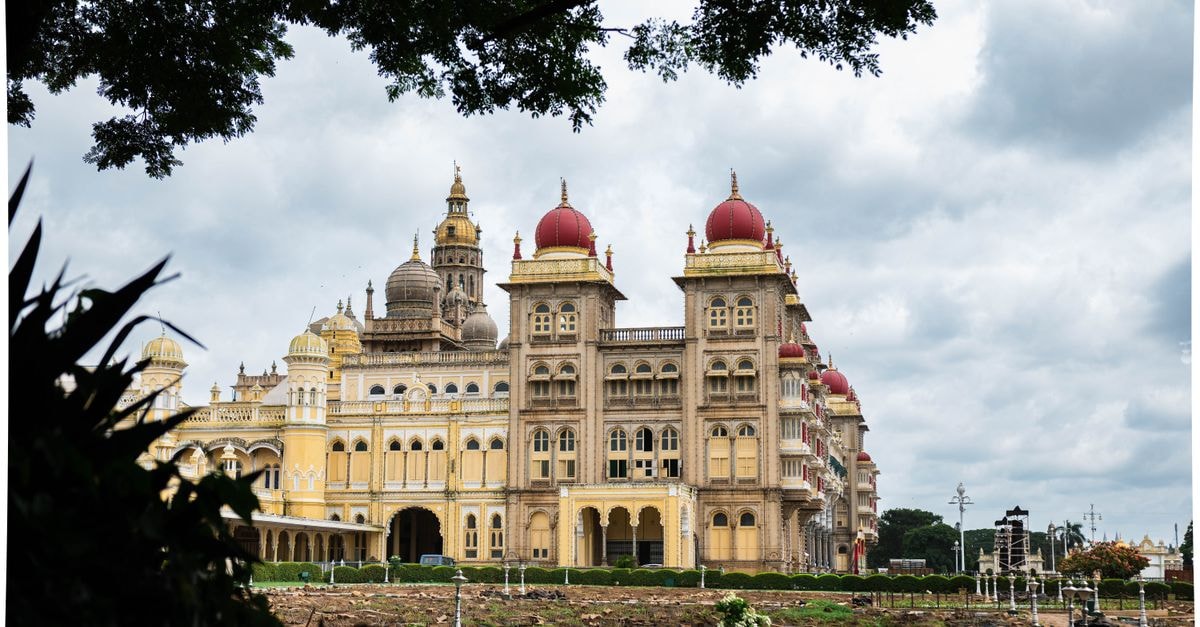 Bijapur travel guide: domes, dynasty routes and North Karnataka flavors Stunning daytime view of Mysore Palace with lush greenery and cloudy sky.
