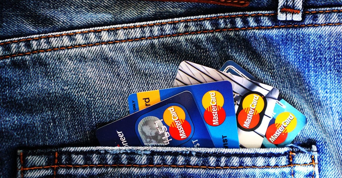 Mastercard exits Pine Labs, sells 4.31% stake for Rs 933 crore Close-up of a denim pocket with multiple credit cards, illustrating finance and fashion.