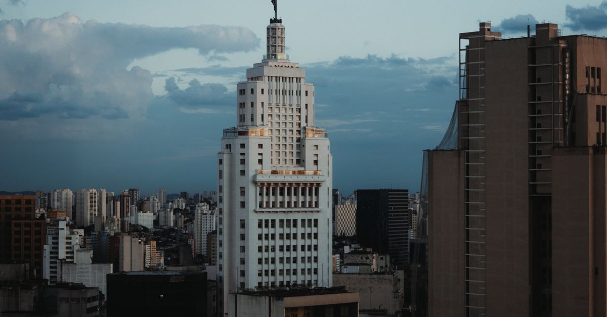 A striking view of an iconic skyscraper in São Paulo's cityscape against a cloudy sky.