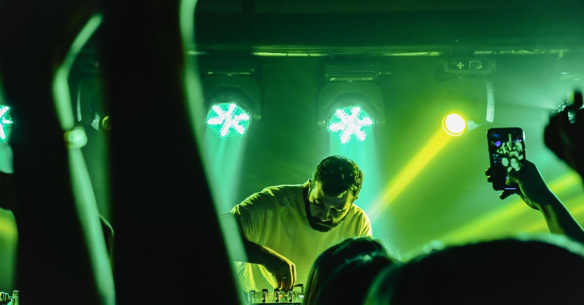 European EDM Promoters Bet on Heritage Castles as Fort X and Black Coffee Headline New Castle-Set Events DJ performing at a lively nightclub in Samsun, Türkiye with vibrant green lights.