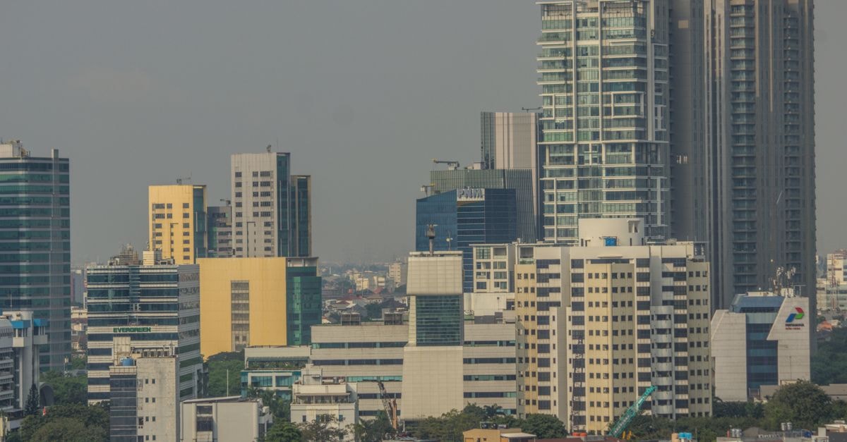 Hotel Alpha Makassar, Makassar — A Jalan Pelita Raya Base Near Panakukkang and Pettarani A vibrant cityscape showcasing diverse high-rise buildings under a clear sky.