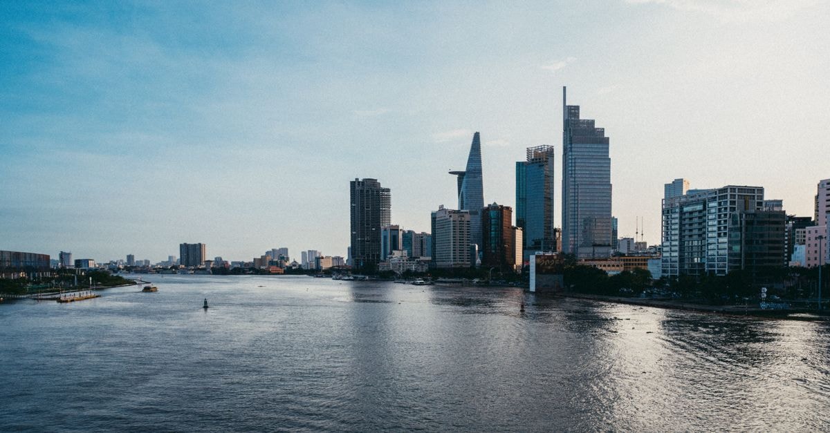 A stunning view of Ho Chi Minh City's skyline reflected in the river at dusk.