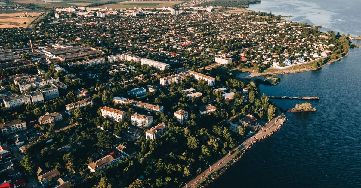 Drone view of a coastal city with urban sprawl and sea meeting the shoreline.