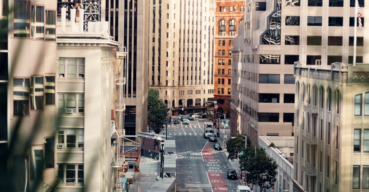 San Francisco Travel Guide: Planning Tips, Costs and Things to Do A bustling urban street surrounded by modern high-rise buildings during the day.