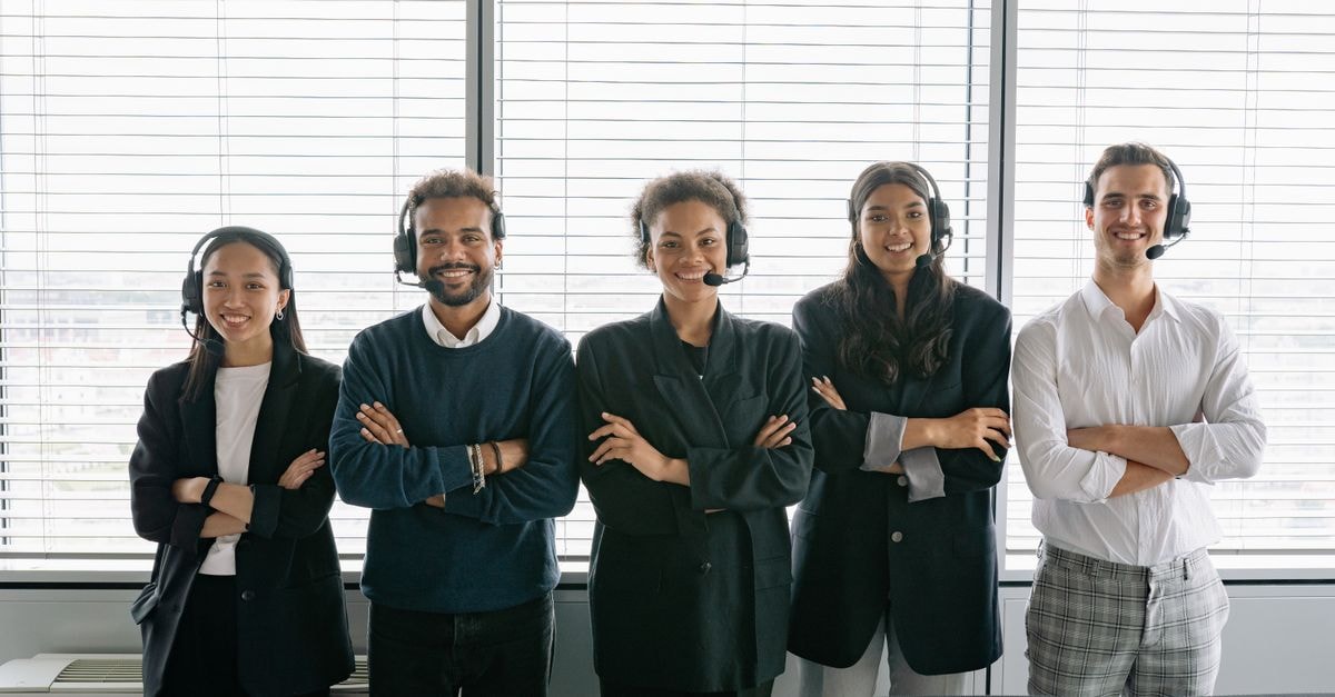 RMR Group: Contracted Fees, Concentrated Clients, and a Quarter That Tests Both Diverse group of smiling customer service agents wearing headsets in modern office.