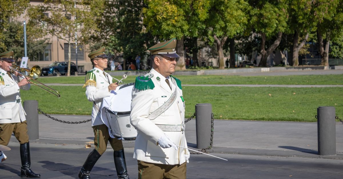 Avex to stream "a-nation 2026" live on YouTube and TikTok from Odaiba Chilean national police band performing in public parade in Santiago, Chile. Formal uniforms and instruments displayed.